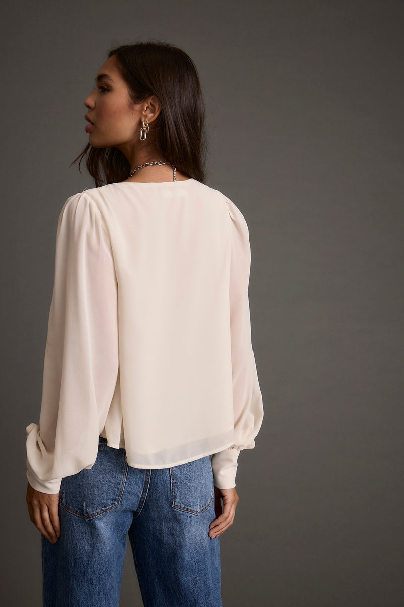 Alternate angle of the ivory blouse highlighting the overall design.