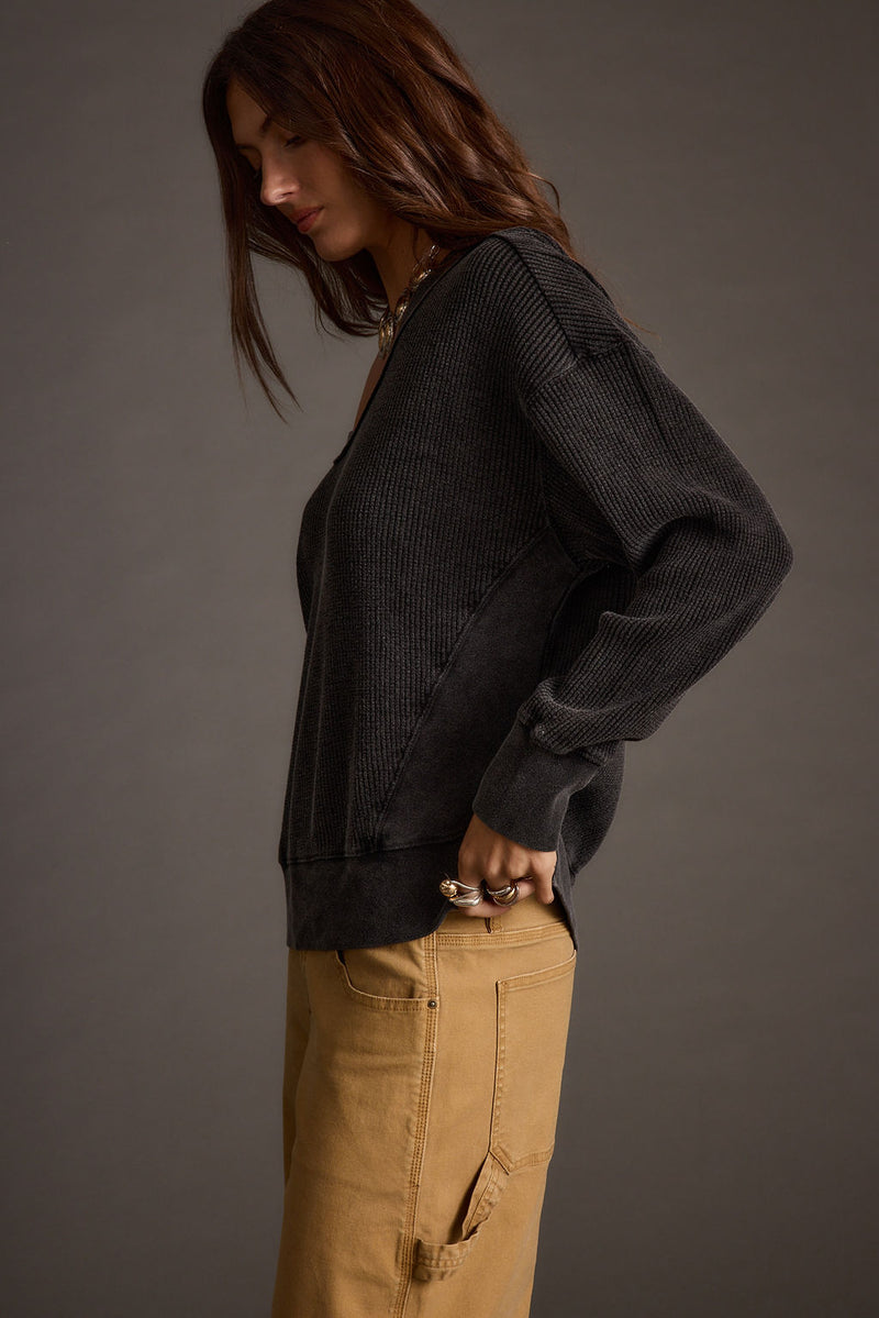 Lifestyle shot of the black top styled for day-to-night versatility.