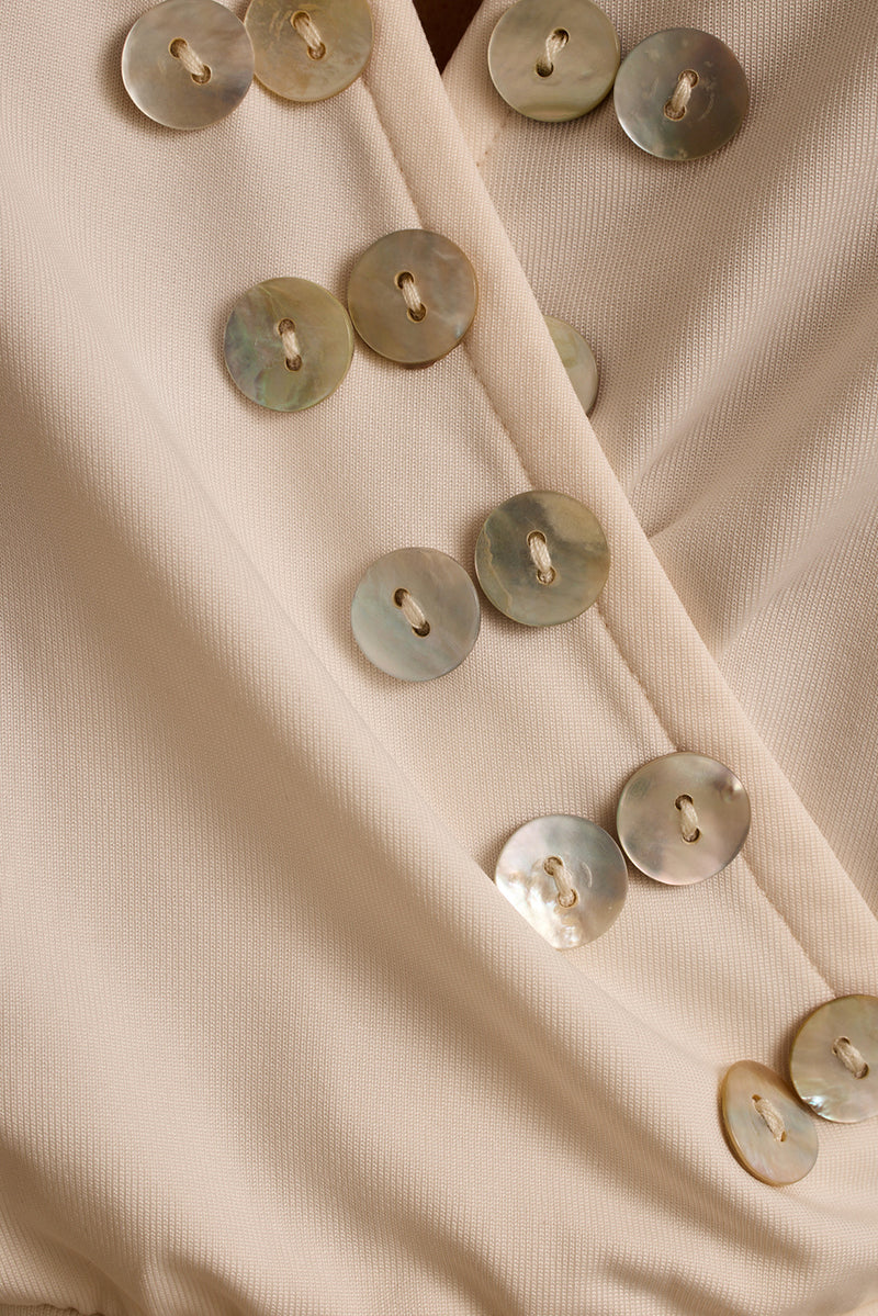 Close-up of mother-of-pearl shell buttons on the ivory Venice halter top.