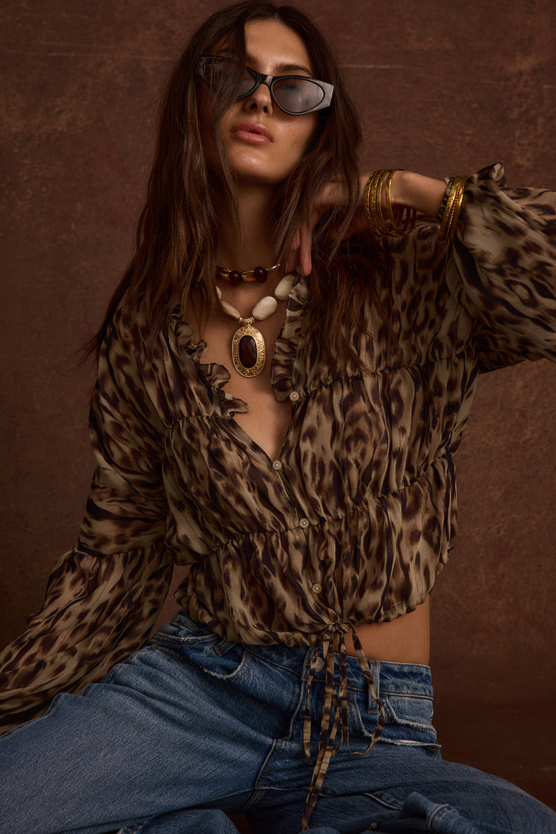 Lifestyle shot of the leopard print blouse styled for day-to-night versatility.