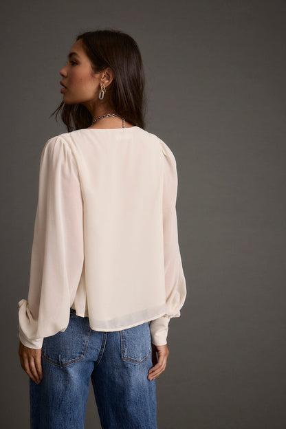 Alternate angle of the ivory blouse highlighting the overall design.