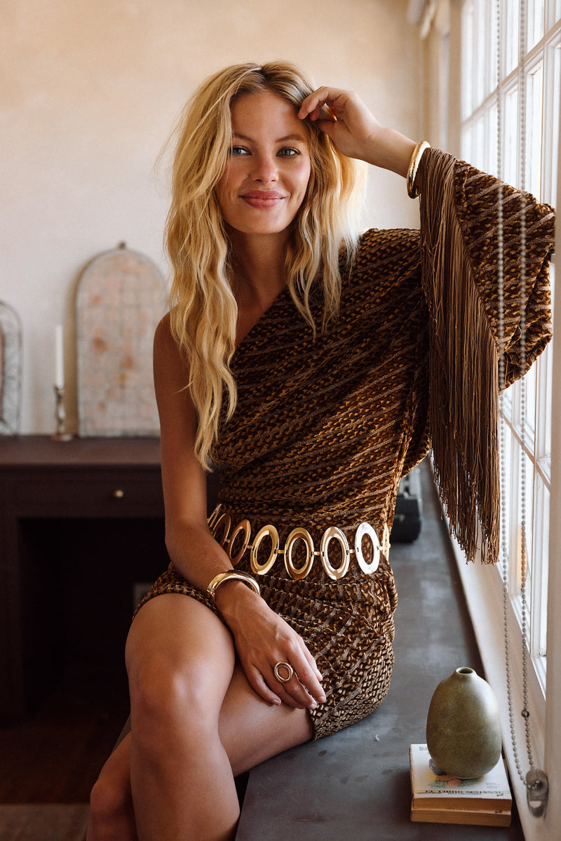 Full-length view of the cognac mini dress showing the drape and movement.