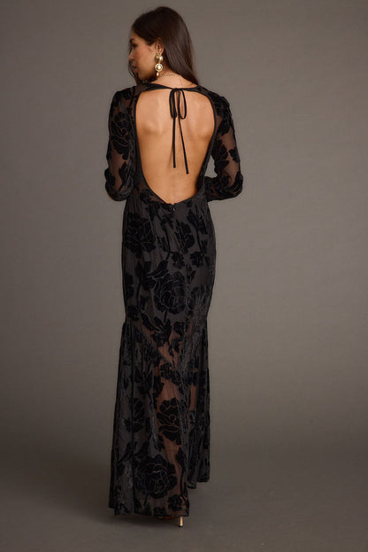 Full-length view of the black maxi dress showing the drape and movement.