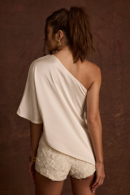 Close-up of the Anya Ivory One Shoulder Top showcasing the fabric texture and design details.