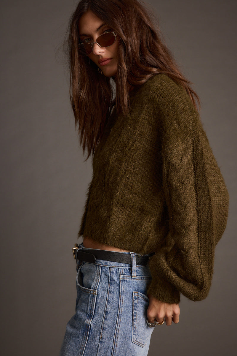 Full-length view of the olive cardigan showing the drape and movement.