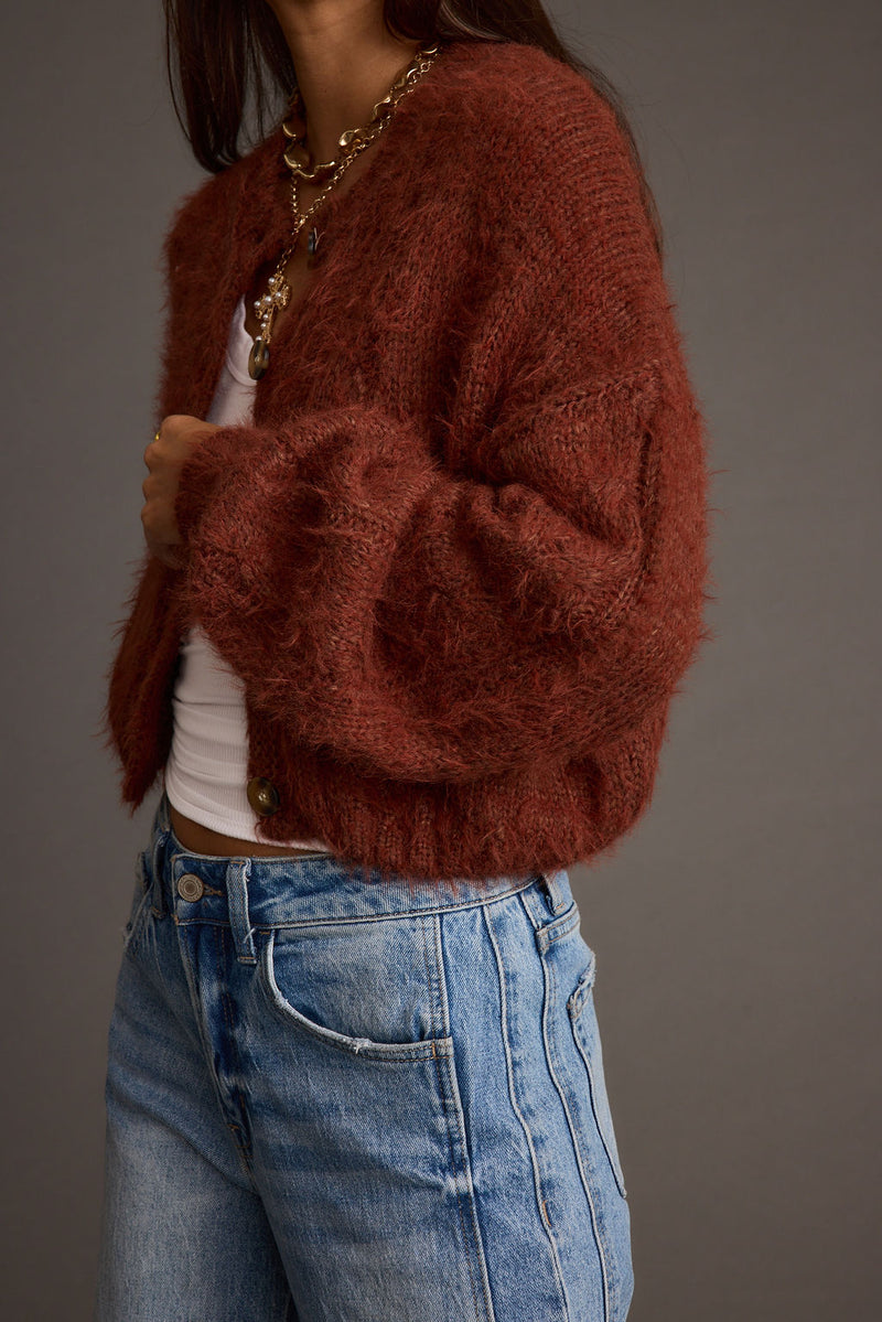 Rust cropped cardigan with refined detailing and a flattering silhouette.