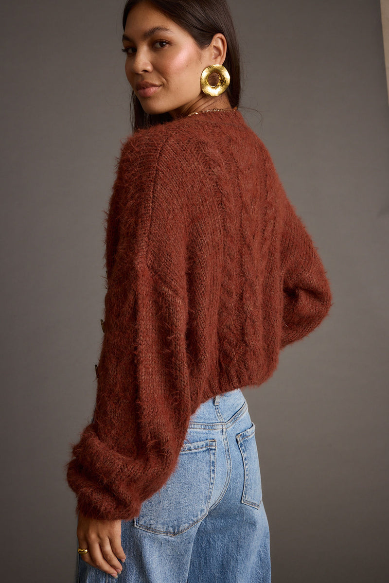Back view of the rust cardigan showing the silhouette and fit.