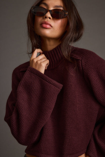 Full-length view of the plum sweater showing the drape and movement.