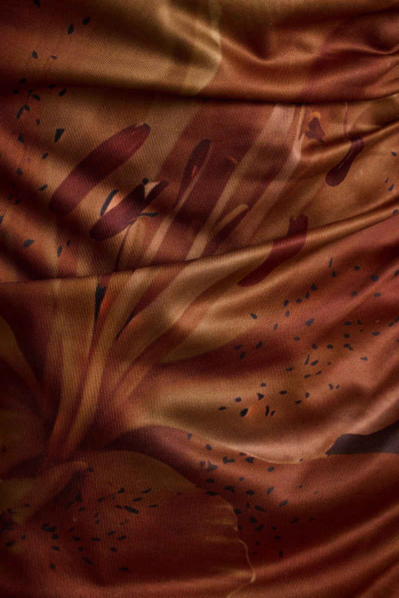 Close-up of mocha floral print on ruched mesh maxi dress fabric.