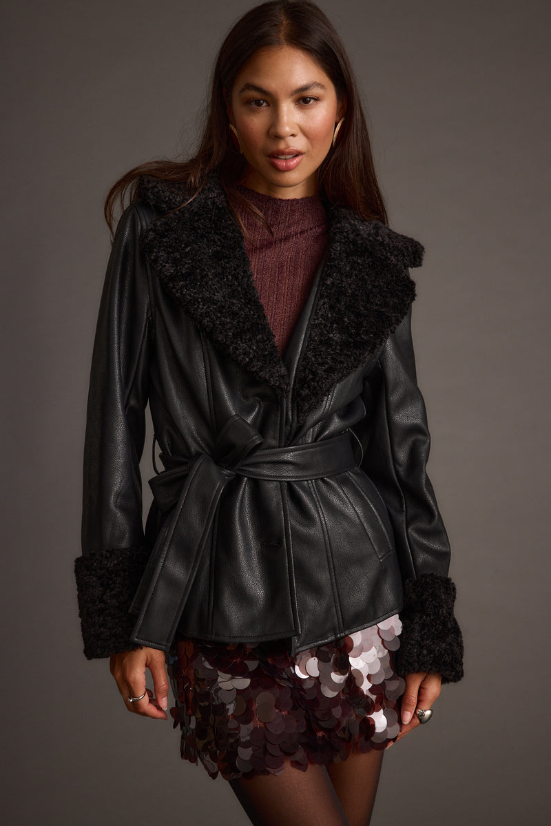 Black jacket with refined detailing and a flattering silhouette.