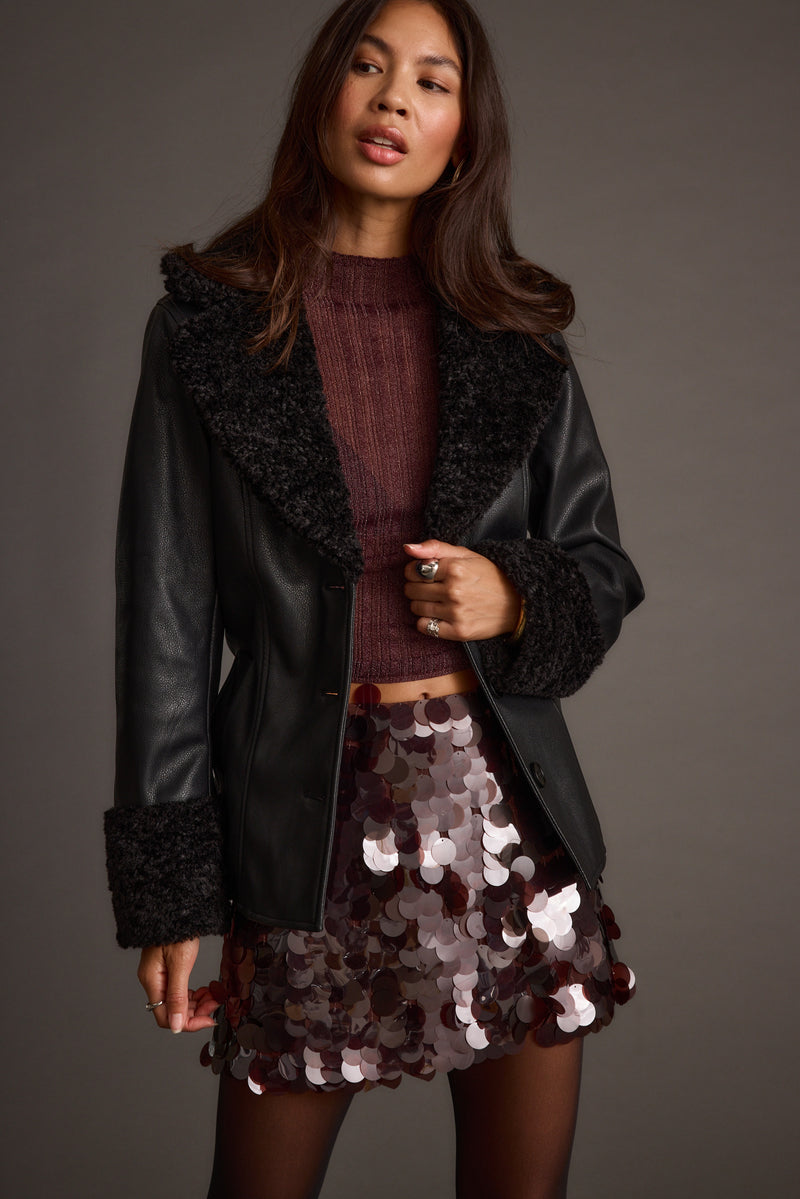 Full-length view of the black jacket showing the drape and movement.