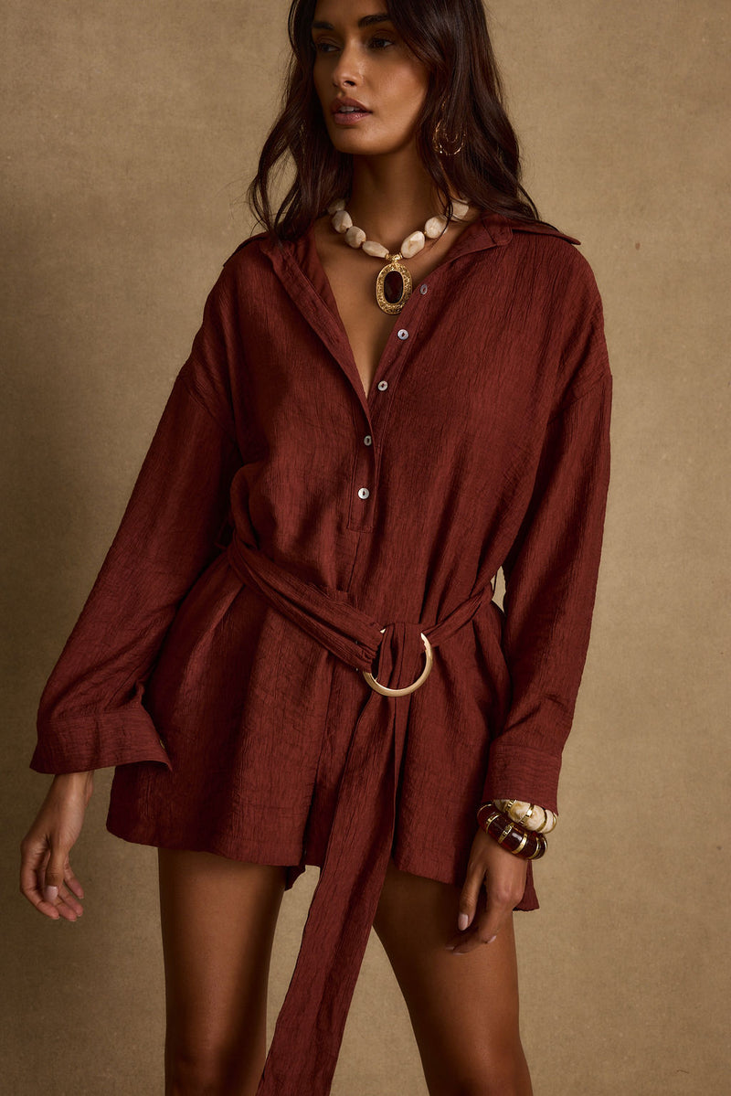 Lifestyle shot of the rust romper styled for day-to-night versatility.