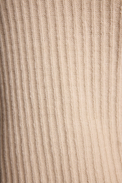 Full-length view of the cream sweater showing the drape and movement.