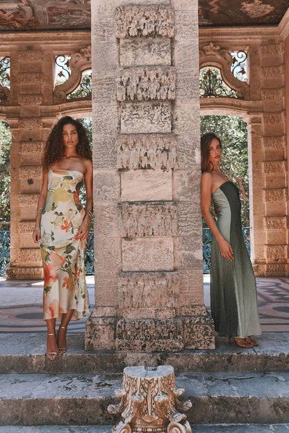 Camille floral strapless satin maxi dress on cream base, styled at a stone villa terrace.