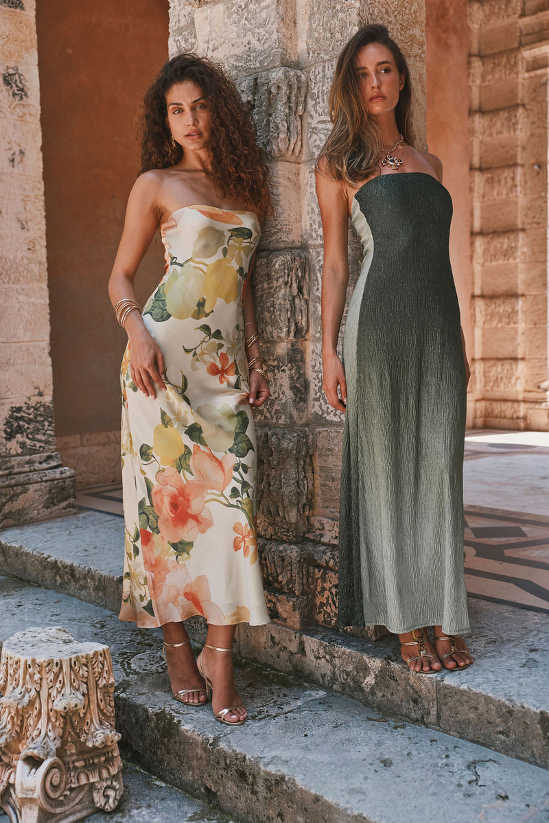 Camille floral strapless maxi dress in cream satin, styled with gold heels by stone columns.