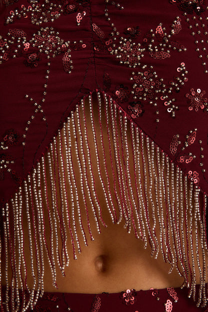 Close-up of mulberry beaded halter top with silver fringe hem and sequin floral detail.