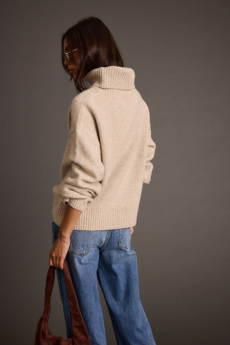 Close-up of the Cedar Oatmeal Oversized Sweater Turtleneck showcasing the fabric texture and design details.
