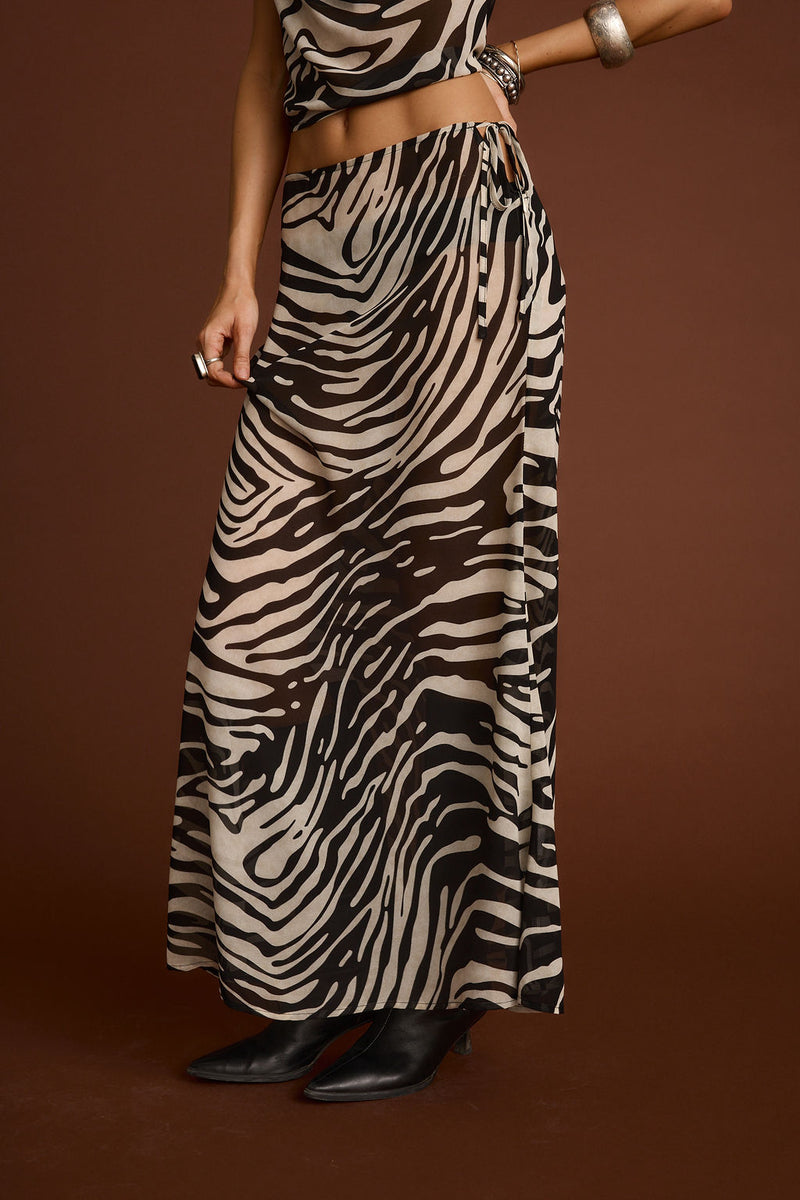 Full-length view of the zebra print maxi skirt showing the drape and movement.