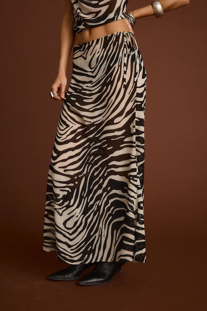 Full-length view of the zebra print maxi skirt showing the drape and movement.