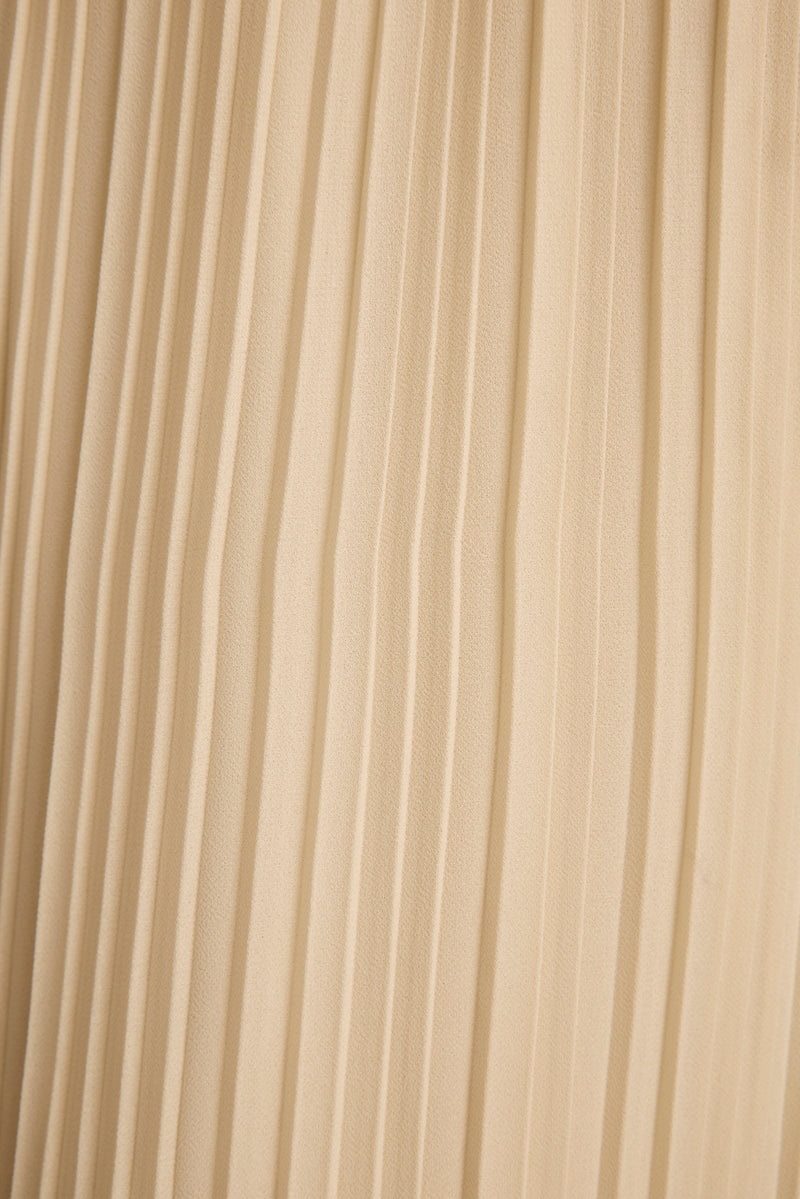 Close-up of cream plisse pleated fabric texture on the Costa halter top.