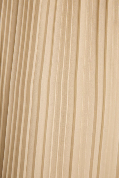 Close-up of cream plisse pleated fabric texture on the Costa halter top.