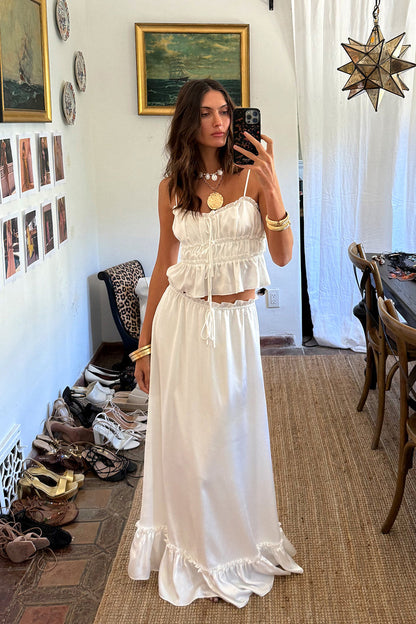 Full-length view of the white maxi skirt showing the drape and movement.
