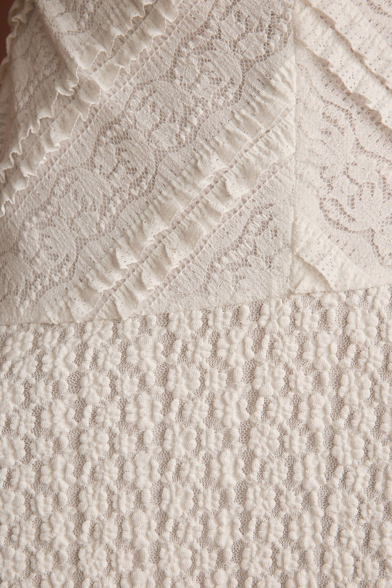 Lifestyle shot of the white mini dress styled for day-to-night versatility.