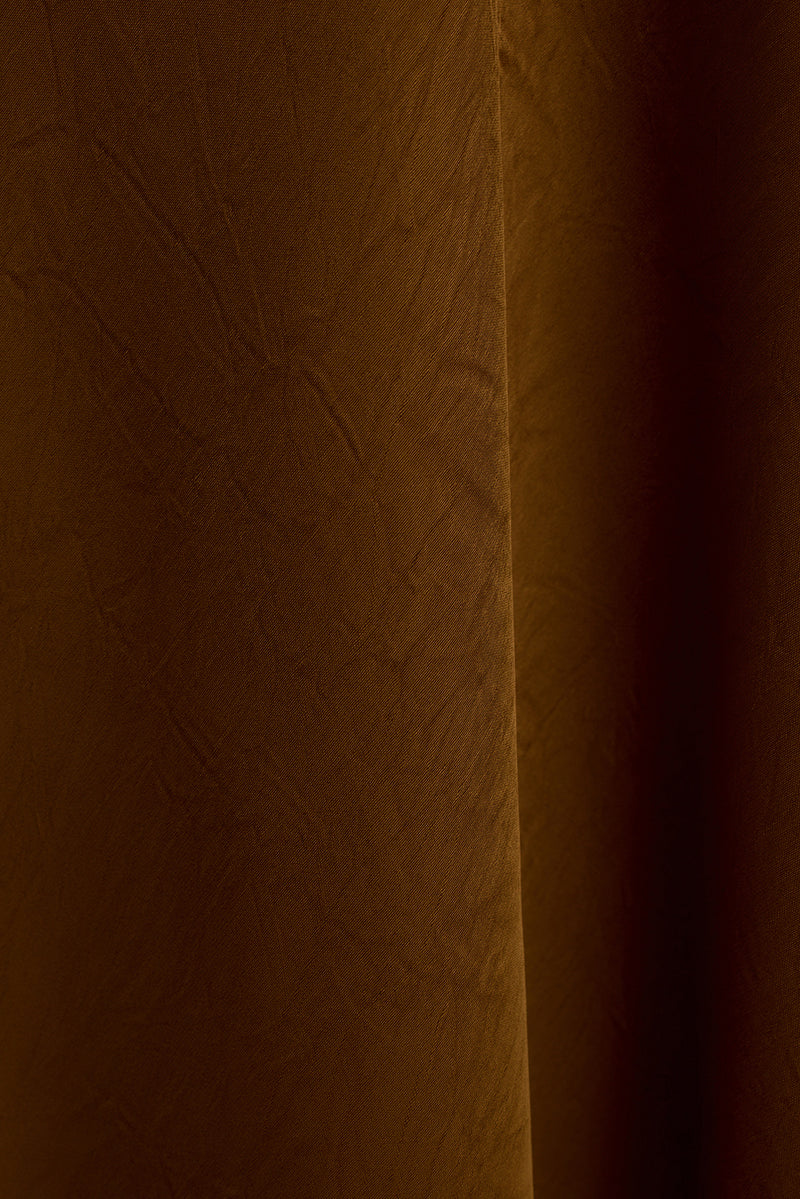 Close-up of the Fia gold satin maxi dress fabric showing soft draping and sheen.
