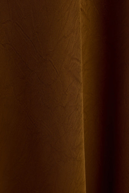 Close-up of the Fia gold satin maxi dress fabric showing soft draping and sheen.