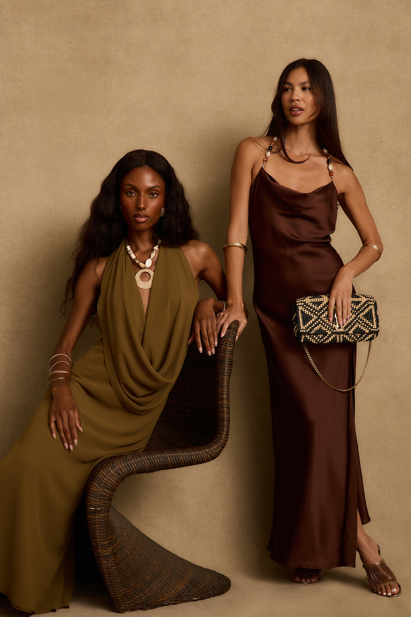 Mocha satin maxi dress with beaded straps and cowl neck, worn standing with woven clutch.
