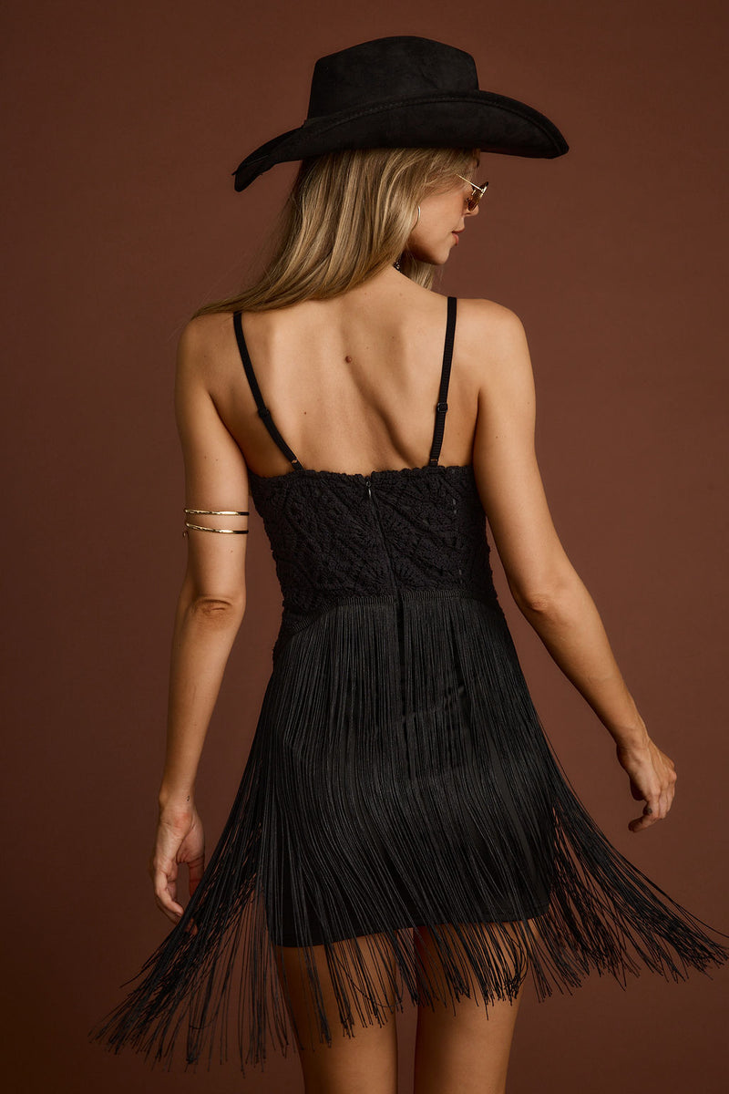 Back view of the black fringe and crochet mini dress showing the silhouette and fit.