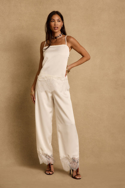 Cream satin tank with lace-trim hem styled with matching wide-leg satin pants on model.