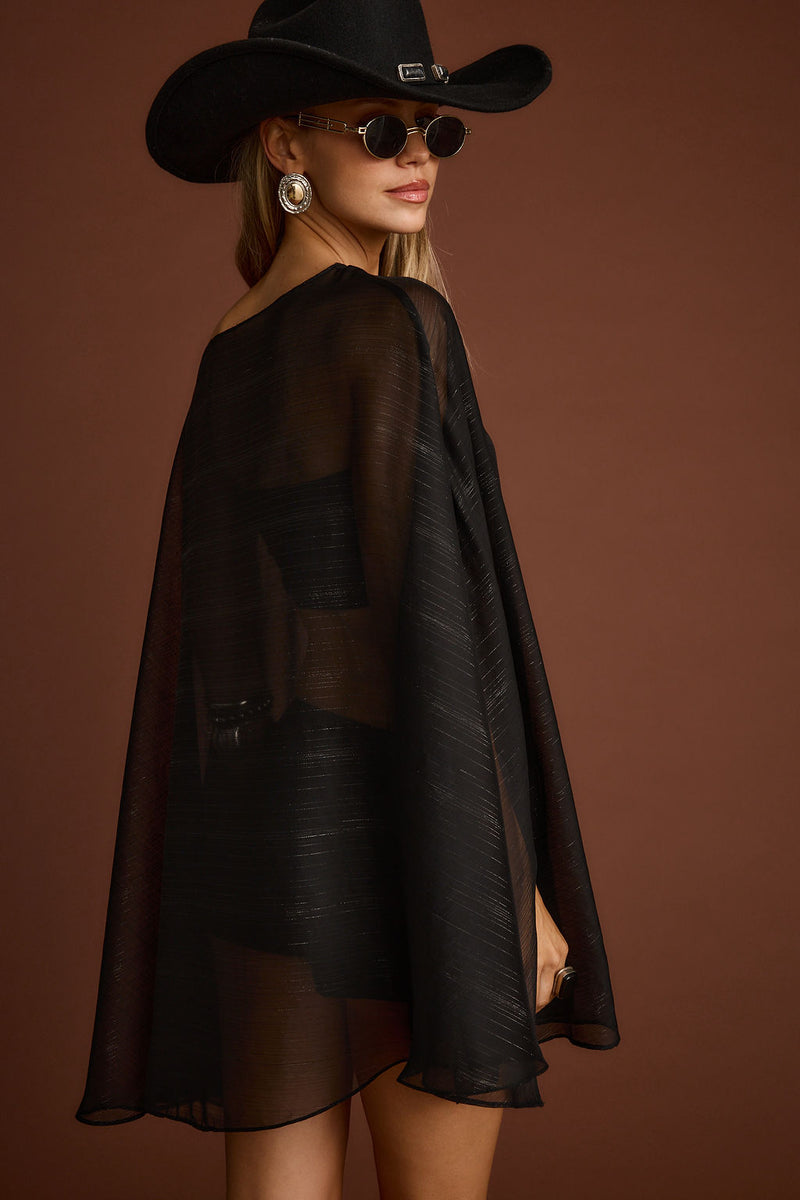 Close-up of the Indie Black Cape Dress showcasing the fabric texture and design details.