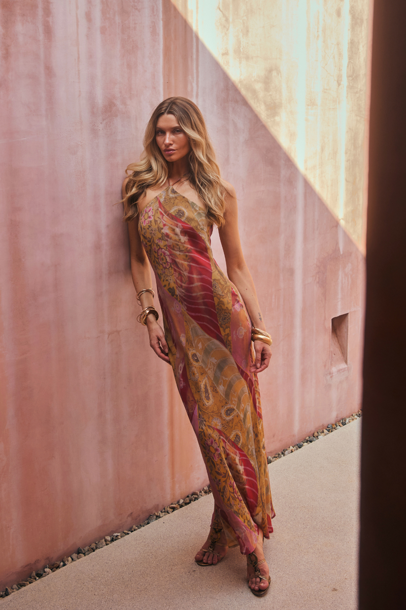 Model wearing the 12th Tribe Isabella Patchwork Maxi Dress, a halter tie-back maxi dress in a sheer, lightweight bias-cut chiffon with patchwork detailing and back neckline gripper tape, perfect for summer soirées, festival-ready looks, and effortless vacation styling