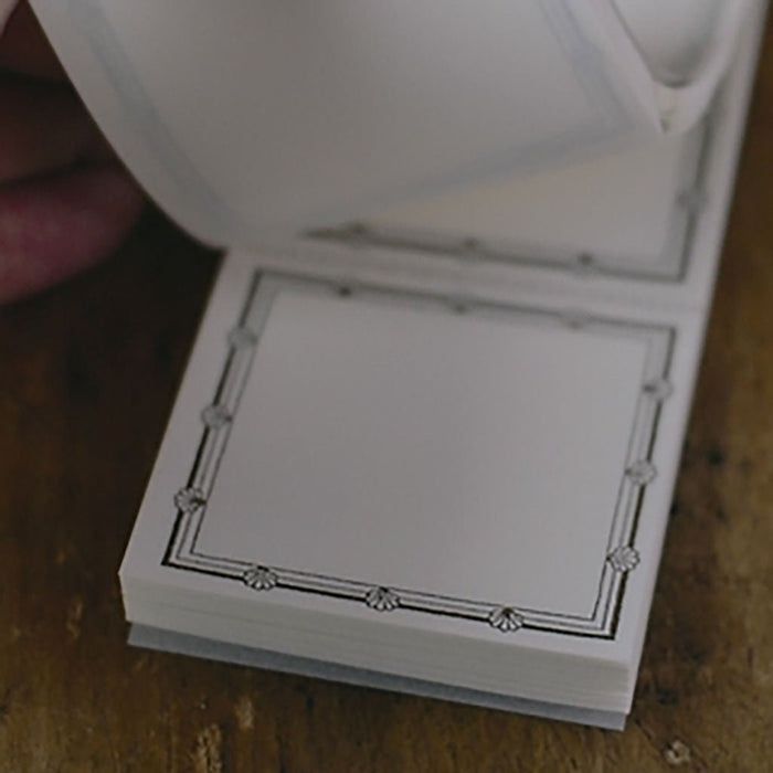a close-up shot of a square label with a decorative border