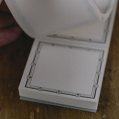 a close-up shot of a square label with a decorative border