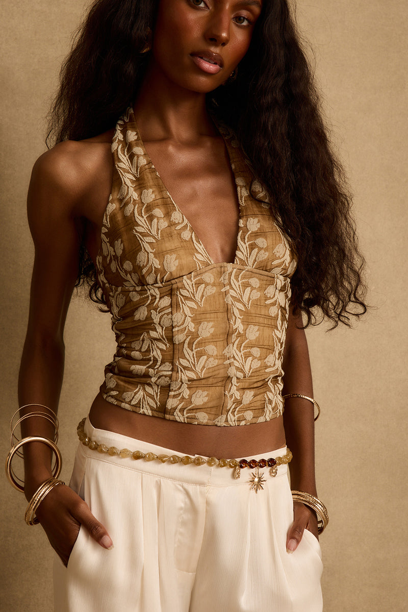 Mocha floral halter top with deep v neckline, styled with cream trousers and gold bangles.