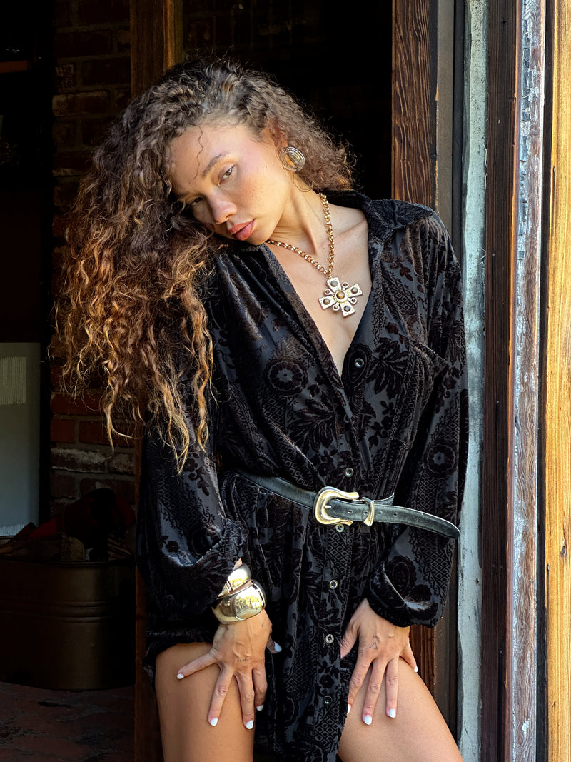 Full-length view of the black mini dress showing the drape and movement.