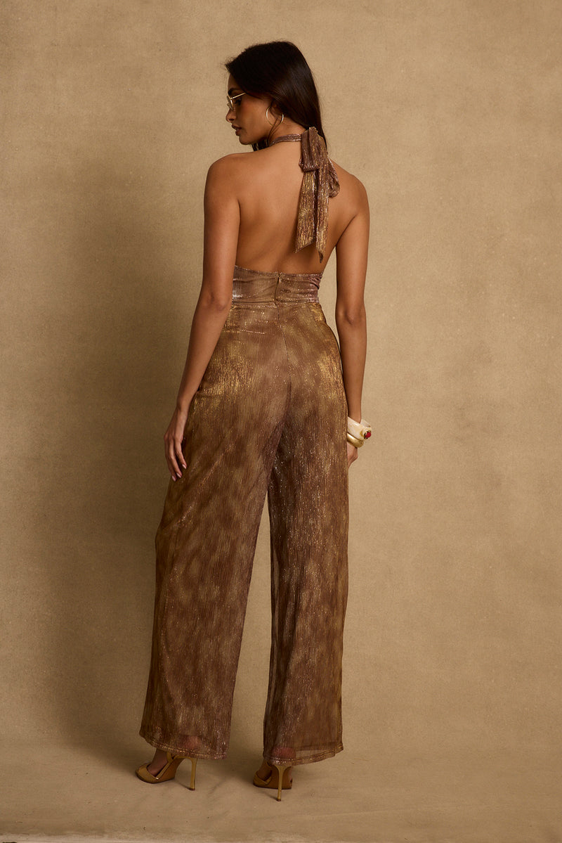 Back view of bronze lurex halter jumpsuit with open back and wide legs.