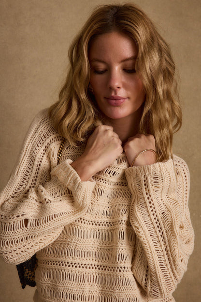 Back view of the cream crochet sweater showing the silhouette and fit.
