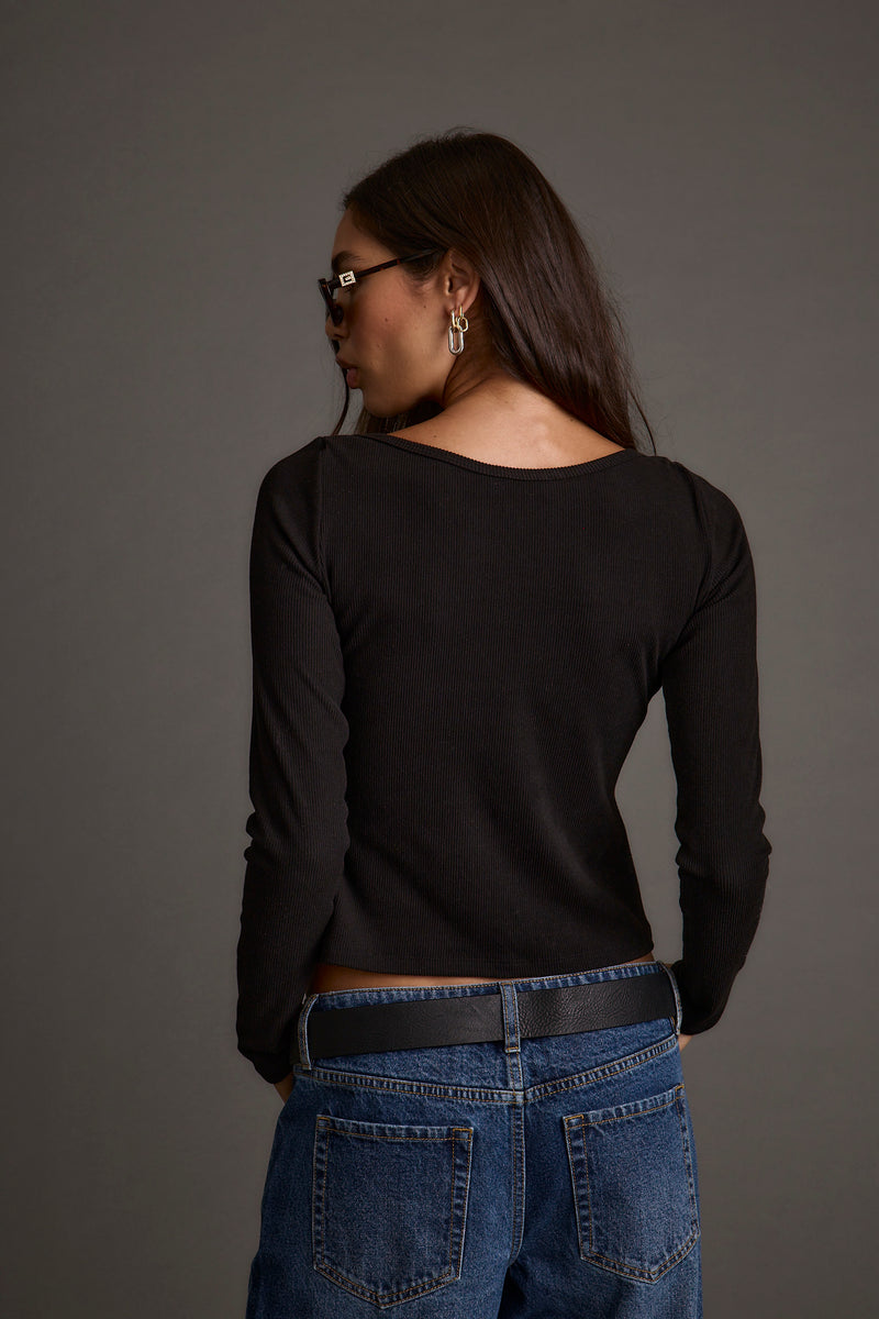 Lifestyle shot of the black top styled for day-to-night versatility.