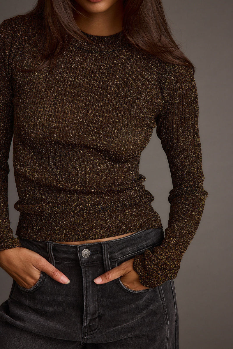 Gold lurex ribbed long sleeve top styled with black jeans, detail of sparkly knit.