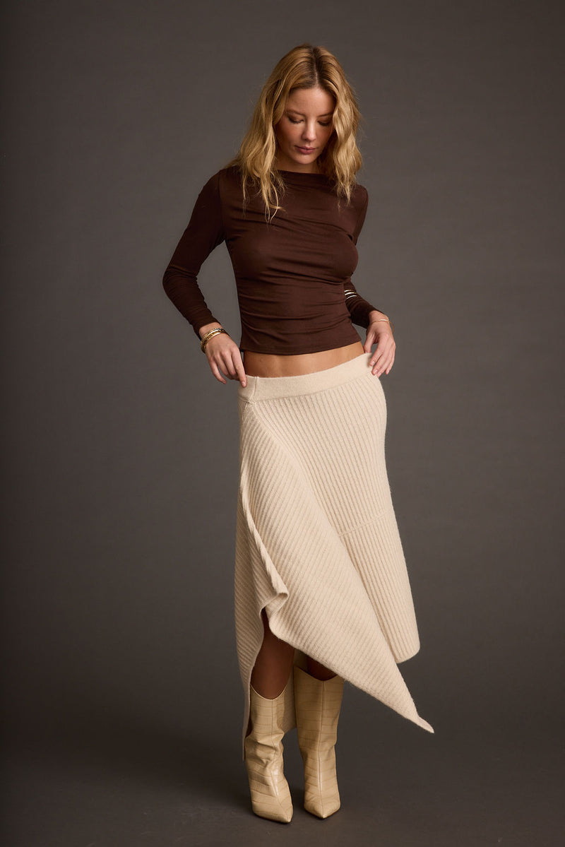 Full-length view of the cream skirt showing the drape and movement.