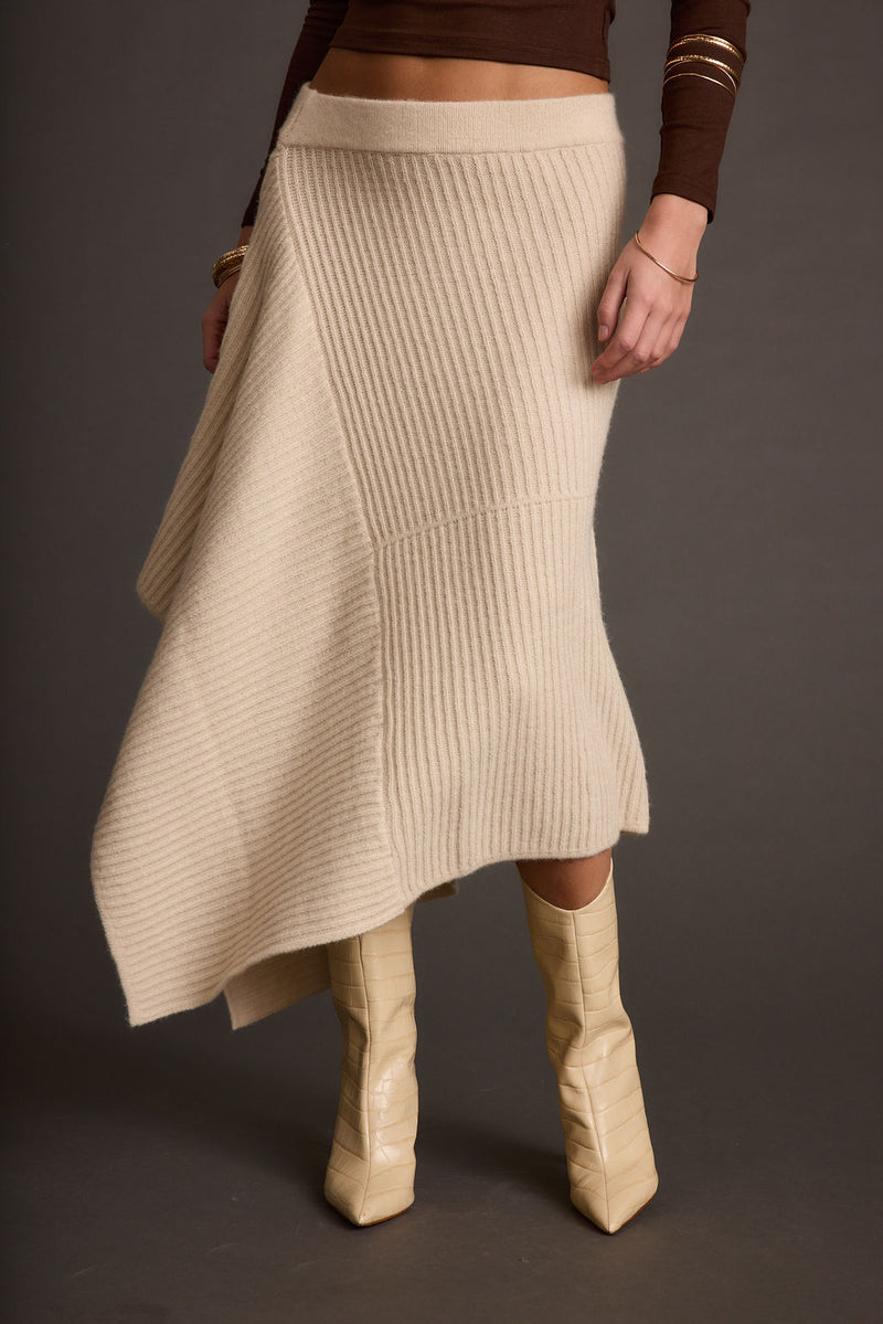 Lifestyle shot of the cream skirt styled for day-to-night versatility.