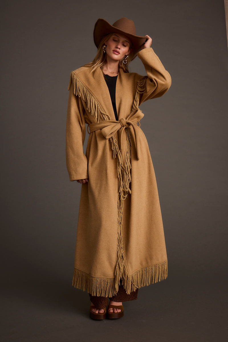 Back view of the camel fringe jacket showing the silhouette and fit.