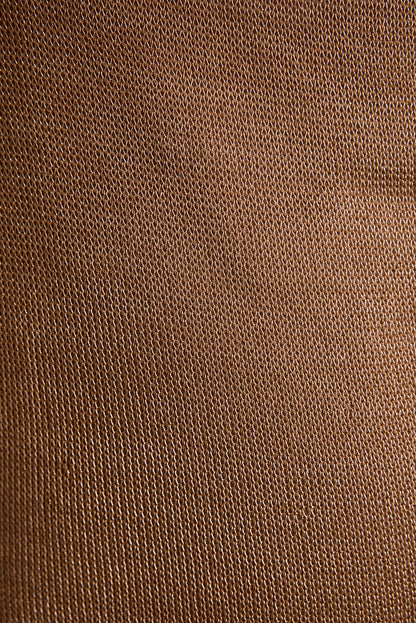 Close-up of rose gold lurex top fabric showing delicate metallic mesh weave texture.