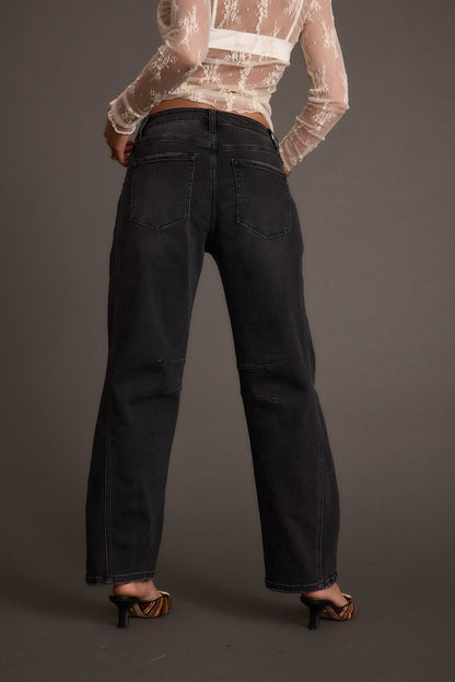 Back view of the black denim jeans showing the silhouette and fit.