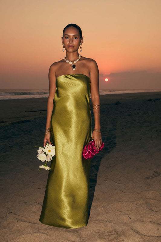 Model wearing the 12th Tribe Natalia Chartreuse Strapless Maxi Dress in a light green satin. Featuring a strapless neckline and elegant maxi silhouette. Style with strappy heels for bachelorette parties, weddings, and vacation dinners.
