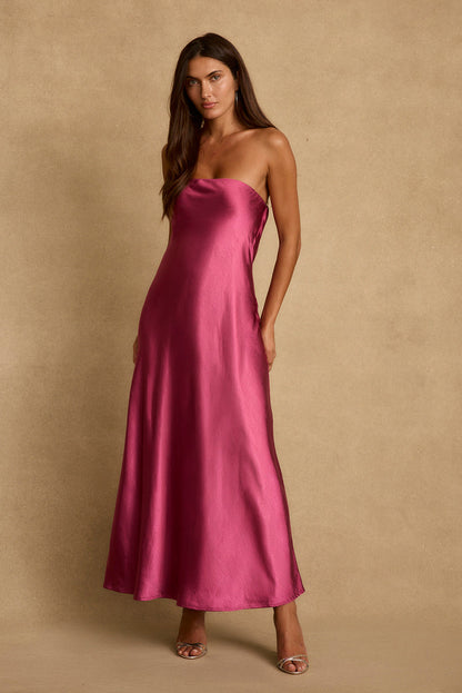 Model wearing the 12th Tribe Natalia Fuchsia Strapless Maxi Dress in a bold pink satin. Featuring a sleek strapless neckline and elegant maxi silhouette. Style with strappy heels for bachelorette parties, festivals, and vacation celebrations.