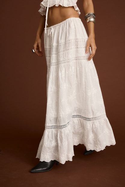 Full-length view of the white maxi skirt showing the drape and movement.